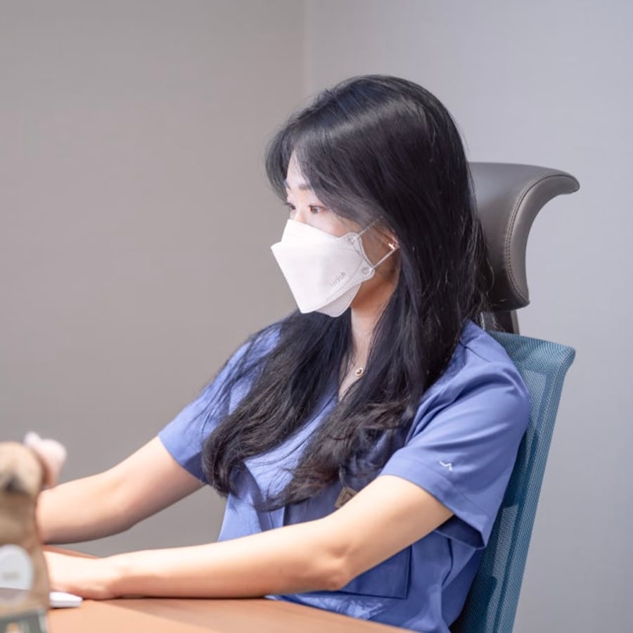 마스크를 쓴 김민지 대표원장이 진료실 책상에 앉아 화면을 보는 옆모습