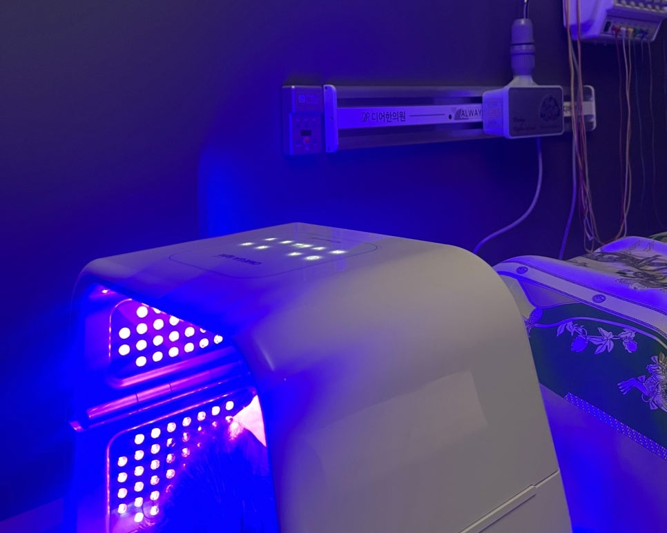 A facial LED device at the head of a treatment bed