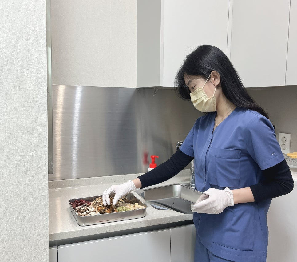 Director Minji Kim preparing herbal medicine at the decoction station in the clinic